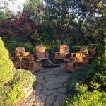 A group of wooden chairs sitting around a fire pit.